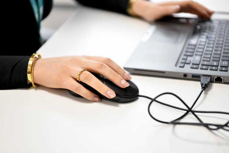 Close up of employee using mouse and laptop