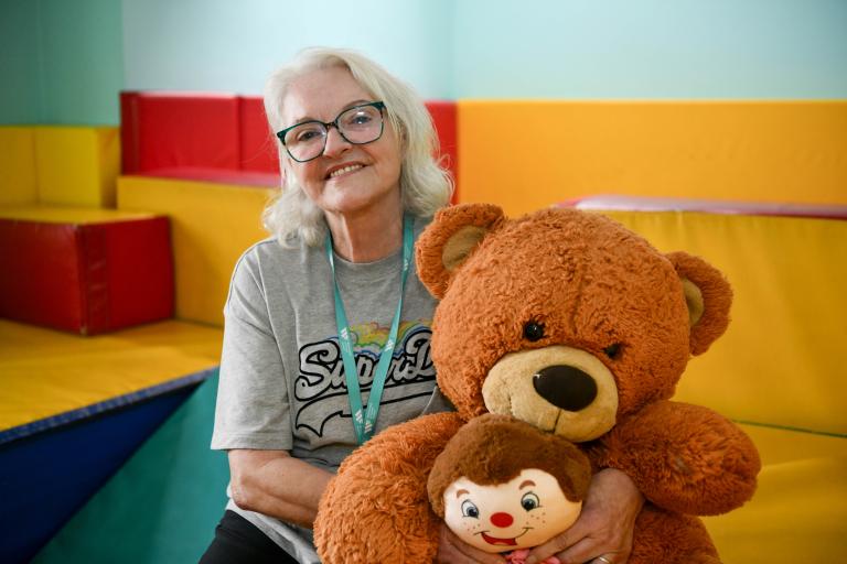 One of our Support Workers in the Children's play area with two teddy bears
