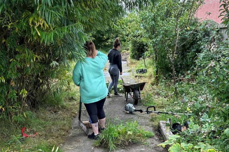 Two people working on restoring a garden in Westmorland and Furness